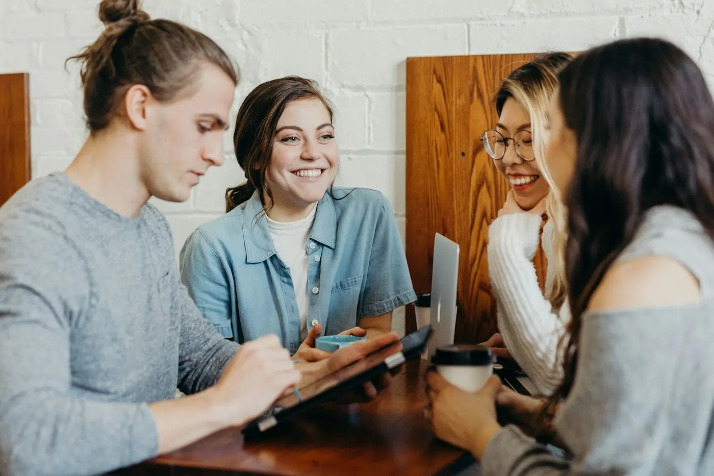 Friends chatting over their phones in a café